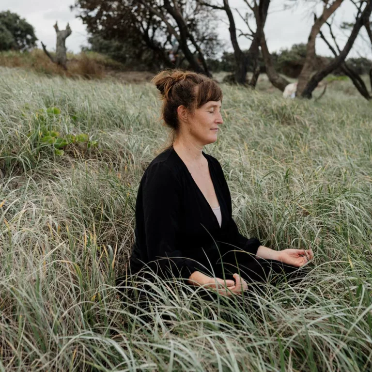 The Reconnected's co-founder, Eleanor, meditating in the sand dunes