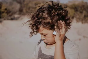 A reconnected child on a beach looking sad